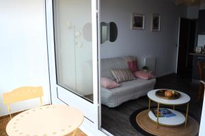 a living room with a couch and a table at L'Esperluette - magnifique vue mer et balcon in Courseulles-sur-Mer