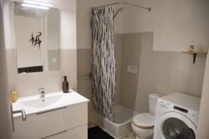 La salle de bains est pourvue d'un lavabo et d'un lave-linge. dans l'établissement El Solà - Appartement avec accès jardin, à Corneilla-de-Conflent
