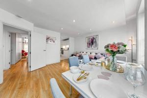 a white dining room with a table and chairs at 3 Bedroom Apartment in Haymarket Central London Sleep 10 HY2 in London