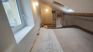 an attic room with a bed and a window at LaMaisonnette 500m plage Juno Beach in Bernières-sur-Mer