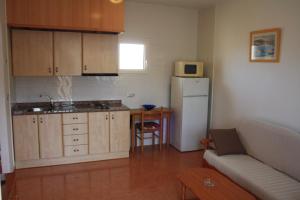 a kitchen with a refrigerator and a table and a couch at Apartamentos turisticos Andrew´s in Puerto de Mazarrón