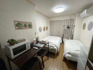 大阪市にあるMulti Stay Osaka Nipponbashi 32の机、コンピューター、ベッドが備わったホテルの部屋