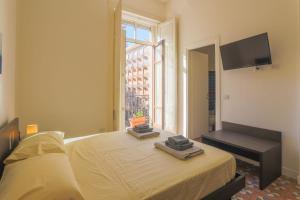 a bedroom with a bed with a tv and a window at B&B Salerno Centrale in Salerno +9 photos