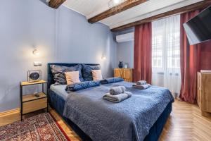 Un dormitorio con una cama azul con toallas. en The Angels Apartments Krakow Old Town, en Cracovia