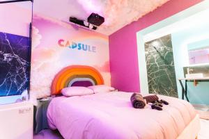 Capsule cloud - jacuzzi - projecteur cinema في توركوان: غرفة بها سرير مع قوس قزح على الحائط