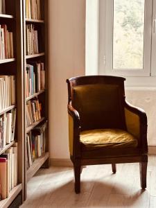 a chair sitting in a room with bookshelves at Villa Ermetica in Breil-sur-Roya
