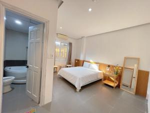 a bedroom with a bed and a bathroom with a tub at LUX hotel in Thôn Lại Thê