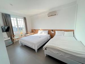 - une chambre avec 2 lits et une télévision dans l'établissement LUX hotel, à Thôn Lại Thê