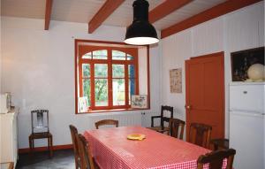 comedor con mesa y mantel rojo en Cozy Home In Plourivo With Kitchen, en Lanleff