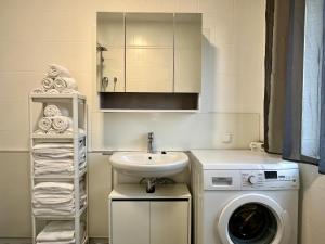 a bathroom with a washing machine and a sink at sHome CityHouse Graz - Self-Check-in in Graz