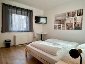 1 dormitorio con 2 camas y TV de pantalla plana en sHome CityHouse Graz - Self-Check-in, en Graz