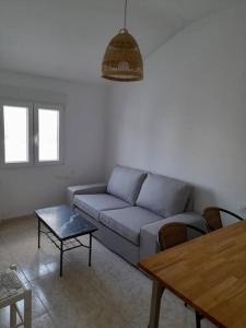 ein Wohnzimmer mit einem Sofa und einem Tisch in der Unterkunft Ático completamente equipado Plaza de España in Ferrol