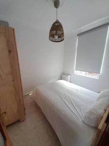 a bedroom with a white bed and a window at Ático completamente equipado Plaza de España in Ferrol