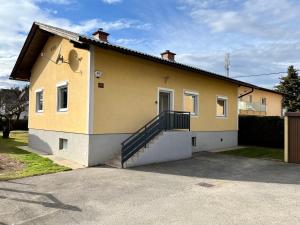 una casa amarilla y blanca con una escalera. en sHome CityHouse Graz - Self-Check-in, en Graz