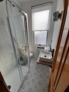 a bathroom with a glass shower and a sink at Ático completamente equipado Plaza de España in Ferrol