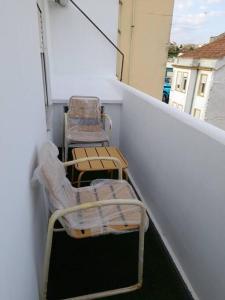 zwei Stühle auf dem Balkon eines Gebäudes in der Unterkunft Ático completamente equipado Plaza de España in Ferrol