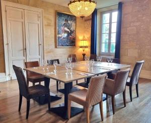 a dining room with a large wooden table and chairs at Château Fleur de Roques - Puisseguin Saint Emilion in Puisseguin