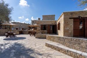 a patio with two picnic tables and umbrellas at Stone Court Boutique Studios in Paphos City