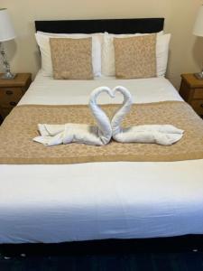 two towels in the shape of a heart on a bed at The Waverley Guest House in Inverness