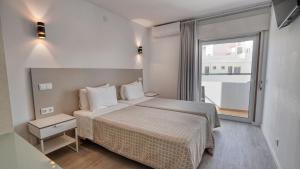 a bedroom with a bed and a large window at Guest House Dianamar in Albufeira