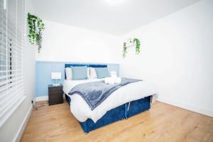 1 dormitorio con 1 cama grande con sábanas azules y blancas en 3 bedroom-Contractors-Professionals, en Gillingham