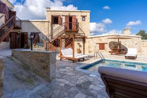 a patio with a swimming pool and a house at Stone Court Boutique Studios in Paphos City