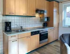 een keuken met houten kasten en een wastafel bij Urlauberdorf Haus 51a in Boltenhagen