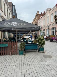 a patio with an umbrella and plants on a street at Vintage room in Tbilisi City