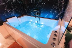 Capsule cloud - jacuzzi - projecteur cinema في توركوان: حوض استحمام به ماء ازرق وشموع