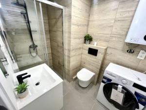 a bathroom with a sink and a toilet and a shower at Apartament Julia 1-4 os parter Centrum in Kielce