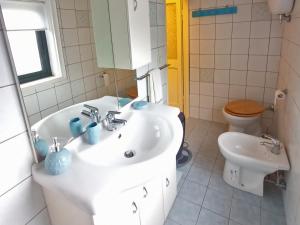 a white bathroom with a sink and a toilet at Apartment in Gallinaro with stunning views in Gallinaro