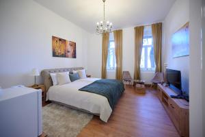 a bedroom with a bed and a flat screen tv at Čudesni drvored in Kikinda
