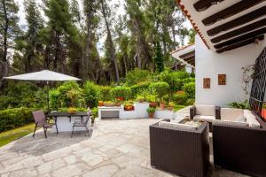 a patio with a table and chairs and an umbrella at The Gift Sani Villa in Sani Beach +50 photos