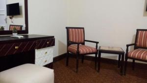 a room with two chairs and a dresser with a mirror at Cairo Paradise Hotel in Cairo