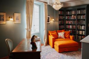 a living room with an orange couch and a table at La Maison de Platane B&B in Fayence