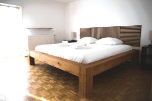 1 dormitorio con 1 cama grande con sábanas blancas en Cozy 3 bedroom house with 11 kw electric car charger, en Hesperange