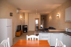 a kitchen with a table and chairs and a room at Ta' Pupa Farmhouse - Sannat in Sannat