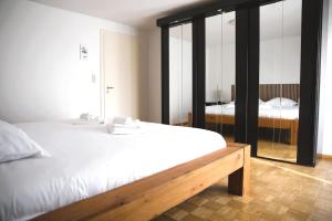 a bedroom with a white bed and a mirror at Cozy 3 bedroom house with 11 kw electric car charger in Hesperange