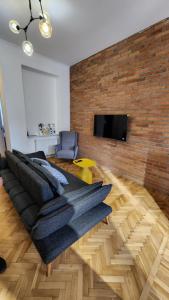 a living room with a couch and a brick wall at Apartment 1905 in Tbilisi, Avlabari in Tbilisi City