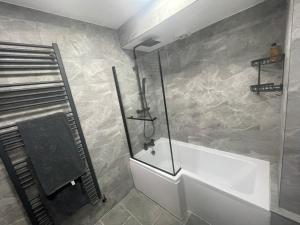 a bathroom with a shower and a bath tub at Garden Apartment nr Heathrow Airport & Elizabeth Line Train Station with Parking for 2 cars in Hayes +9 photos