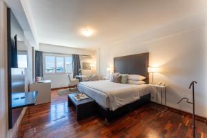 Una habitación de hotel con cama y escritorio y una habitación con en Hotel Tolosa en Puerto Madryn