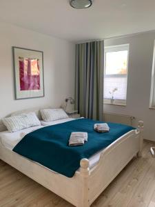 une chambre avec un grand lit avec deux serviettes dessus dans l'établissement Ferienwohnung Ostseeglück, à Boltenhagen