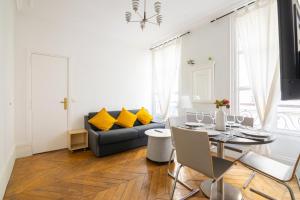 a living room with a table and a couch at Appartement Quartier Musée du Louvre Free Netflix in Paris