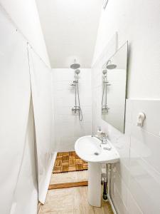 a white bathroom with a sink and a mirror at PINIALE GLAMPING TRIB in Bughea de Jos