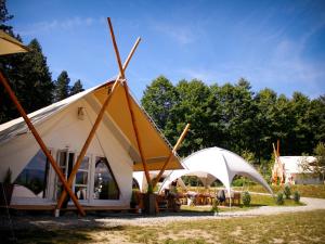 a large white tent with wooden poles at PINIALE GLAMPING TRIB in Bughea de Jos