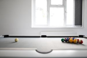 a pool table with balls on top of it at Spacious 4-Bedroom Apt | Pool Table in Cardiff