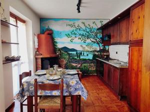 eine Küche mit einem Tisch und einem Gemälde an der Wand in der Unterkunft MadreSila Home in Camigliatello Silano