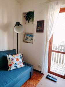 ein Wohnzimmer mit einem blauen Sofa und einem Fenster in der Unterkunft MadreSila Home in Camigliatello Silano