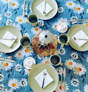 une table avec des assiettes et des tasses sur un tissu de table bleu à fleurs dans l'établissement MadreSila Home, à Camigliatello Silano