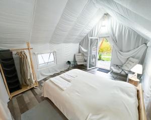 a bedroom with a bed in a tent at PINIALE GLAMPING TRIB in Bughea de Jos
